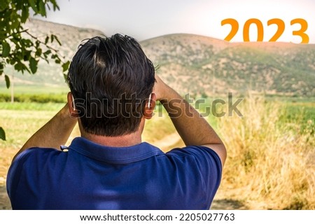 Happy New Year 2023 anniversary concept. Man watching transition from 2022 to new year 2023 concept with the text on sky. High resolution photo for large displays, print, banners.