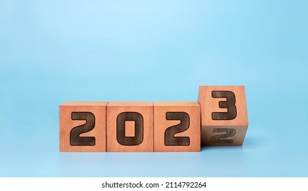 Happy new year 2023 . new year background concept,  flipping wooden cubes 2022 to 2023 with blue background.