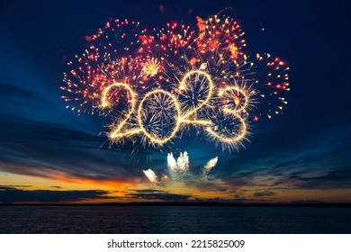 Happy New Year 2023. Beautiful creative holiday web banner or flyer with red fireworks and Golden sparkling number 2023 on blue sky  over sea - Shutterstock ID 2215825009