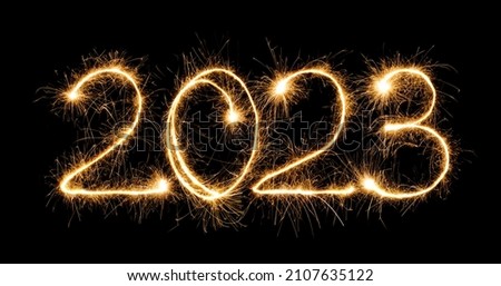 Happy New Year 2023. Burning sparkling text 2023 isolated on black background. Beautiful Glowing design element for greeting card and holiday flyer 