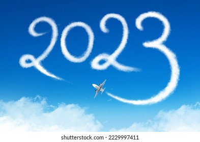 Happy New year 2023 concept travel on the blue background below cloudscape. Drawing by passenger airplane vapor steam contrail in sky