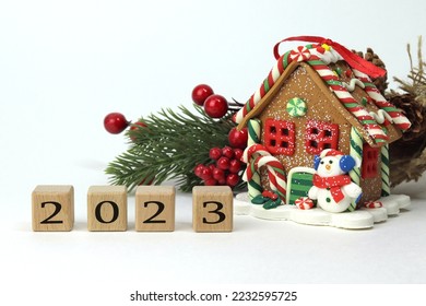 Happy New Year 2023, cookie house and pine branch in the background - Shutterstock ID 2232595725