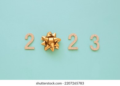 Happy New Year 2023. Golden numbers with rhinestone text 2023 isolated blu background. Beautiful bright design element for greeting card and holiday flyer.