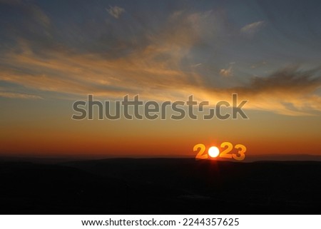 Happy New Year 2023 Idea. Transition from 2022 to new year 2023 concept with text on sun rising sky. Goodbye 2022 welcome 2023. Creative Concept.	