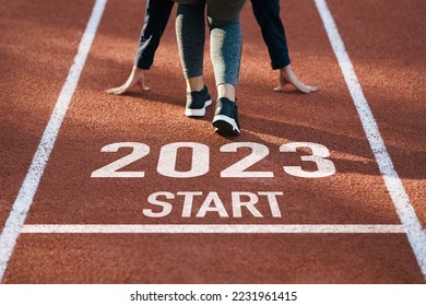 happy new year 2023 symbolizes the start of the new year. Rear view of a man preparing to run on the athletics track engraved with the year 2023. The goal of Success.Getting ready for the new year - Shutterstock ID 2231961415