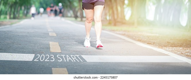 happy new year 2023,2023 symbolizes the start of the new year. Start with a woman preparing to run on the road engraved with the year 2023. The goal of Success. Getting ready for the new year	 - Powered by Shutterstock