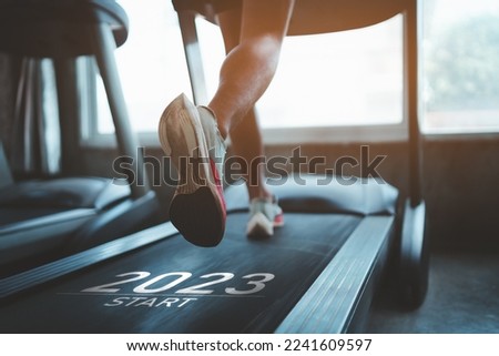 Happy new year 2023,2023 symbolizes the start of the new year. Close up of feet, sportman runner running on treadmill in fitness club. Cardio workout. Healthy lifestyle, guy training in gym.