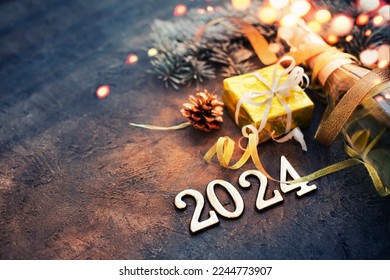 happy new year 2024 card with bottle of champagne and present gift over dark stone background - Powered by Shutterstock