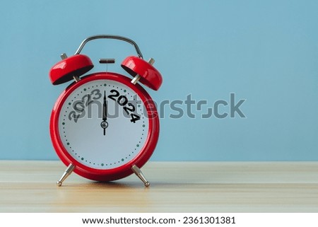 Happy new year 2024 concept.2023 change to 2024 on alarm clock on blue background.Copy space and banner for text.