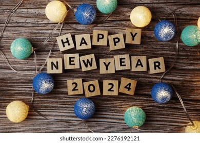 Happy New Year 2024 decorate with LED cotton ball on wooden background