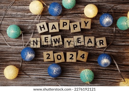 Happy New Year 2024 decorate with LED cotton ball on wooden background