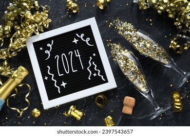 Happy New Year 2024 - gold confetti and champagne sparkling wine glasses