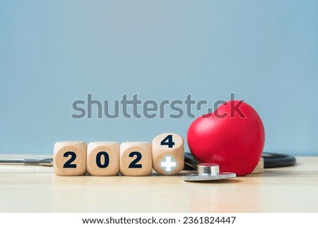Happy New Year 2024 for health care and medical concept.Wooden block with 2024 number and medical sign.Red heart and stethoscope.