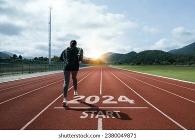 Happy New Year 2024 symbolizes the start of the new year. Woman preparing to run on the athletics track is engraved with the year 2024. start challenge goal of planning health and business to success - Powered by Shutterstock