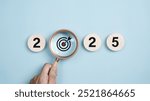 Happy new year 2025 with business concept. 2025 year number with Target icon inside the golden magnifying glass on light blue background. Planning for goal and success concepts. New Year resolution