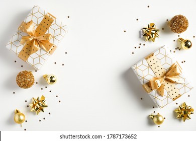 Happy New Year banner. Christmas design gold gifts box, golden balls, glitter confetti stars on white background. Decoration objects viewed from above. - Powered by Shutterstock