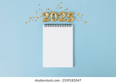 Happy New year and Christmas holiday concept 2025 with empty notebookon blue background
