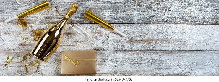 Happy New Year Concept With All Golden Objects Such As A Bottle Of Champagne, Drinking Glasses And Party Decorations 