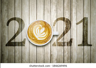 Happy New Year Concept. Top View Of Latte Coffee Art With Number 2021 On The Wooden Table