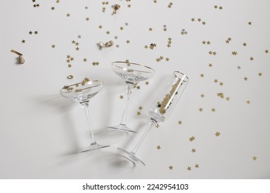 Happy New Year festive background, web banner. Birthday, wedding party celebration. Champagne wine bottles, cocktail drinking glasses on white table backdrop. Golden star confetti. Flat lay, top view. - Powered by Shutterstock