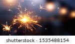 Happy New Year, Glittering burning sparkler against blurred bokeh light background