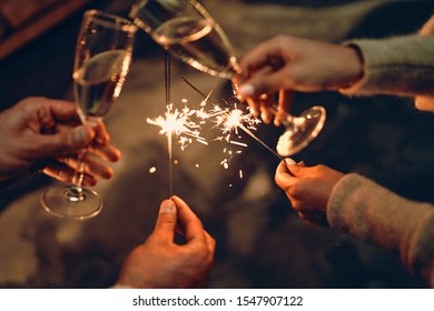 Happy New Year and Merry Christmas! Glasses with champagne in hand and sparklers. - Powered by Shutterstock