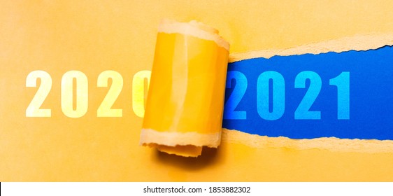 Happy New Year, New Start, New Page Of Life; Resolution Concept. Text Of 2021 On Blue Background In Hole Of Torn Yellow Textured Paper With Text Of 2020.