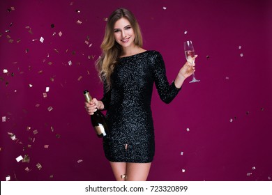 Happy New Year To You! One Beautiful Young Woman With Confetti, Celebration Christmas With Bottle And Glass Of Champagne. New Year's Party. Christmas Eve.