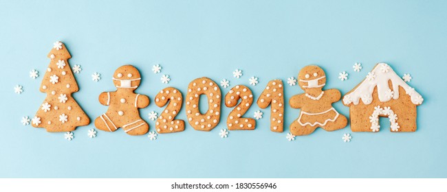 Happy New Year's set of numbers 2021, gingerbread man in face mask from ginger biscuits glazed sugar icing decoration on blue background, minimal seasonal pandemic winter holiday banner - Shutterstock ID 1830556946