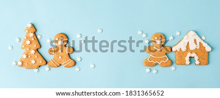 Happy New Year's set of numbers 2022, gingerbread man in face mask from ginger biscuits glazed sugar icing decoration on blue background, minimal seasonal pandemic winter holiday banner