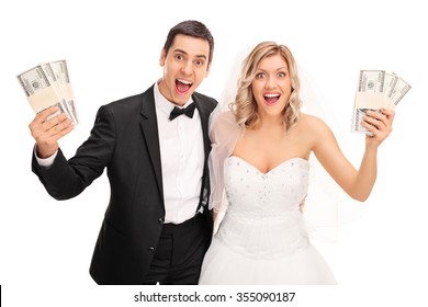 Happy Newlywed Couple Holding Few Stacks Of Money And Looking At The Camera Isolated On White Background