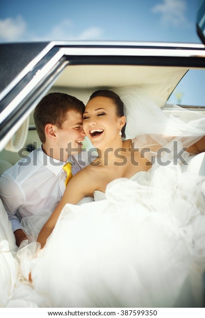 Happy newlyweds have fun in
the car