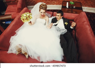 Happy Newlyweds Lie On The Big Red Couch