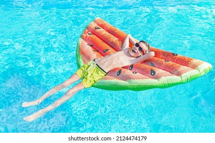 Happy Nine Years Old Child (boy) In Red Sunglasses Lying On The Inflatable Ring (air Mattress) In Swimming Pool. Kid Water Toys, Safety On The Water, Learning To Swim. Family Beach Vacation. Summer.
