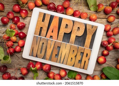Happy November typography  greeting card - word abstract in letterpress wood type on a digital tablet framed by red crab apples