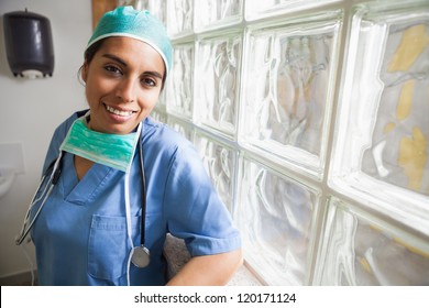 Happy nurse in scrubs leans glass wall in hospital, Healthcare workers in the Coronavirus Covid19 pandemic - Powered by Shutterstock