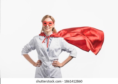 Happy Nurse In Superhero Mask And Cloak Standing With Hands On Hips Isolated On White