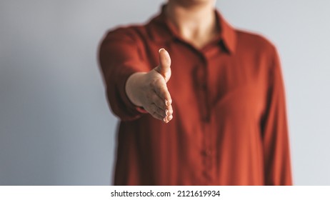 Happy office employee giving hand for shaking . Arm of business woman offering handshake. Professional welcoming colleague or new partner. HR manager hiring greeting at job interview. Close up shot