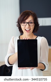 Happy Office Woman, Holding A Tablet Computer With Copy Space In The Screen, Showing Surprised Facial Expression At The Camera.