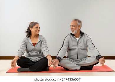 A HAPPY OLD COUPLE LOOKING AT EACH OTHER WHILE MEDITATING
 - Powered by Shutterstock