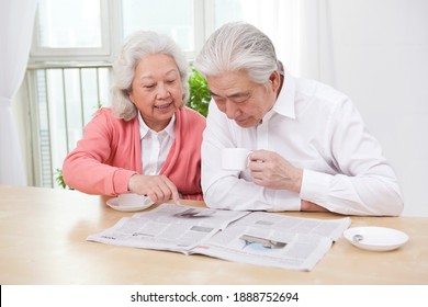 The Happy Old Couple Are Reading The Newspaper High Quality Photo