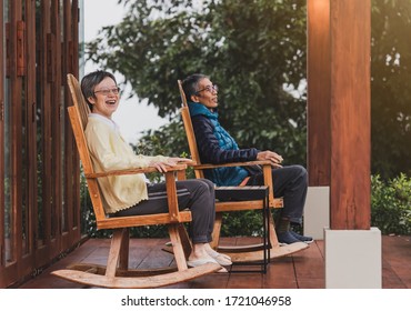 A Happy Old Couple Resting On The Balcony In A Pair Of Rocking Chairs