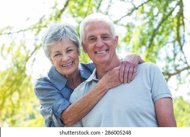 Happy old couple smiling in a park on a sunny day