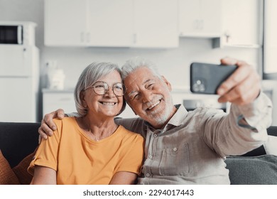 Happy old couple taking selfie on cellphone, smiling senior mature spouses middle aged wife and retired husband laughing holding phone make self portrait on smartphone camera, focus on mobile display - Powered by Shutterstock