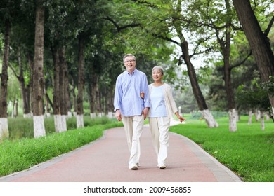 Happy Old Couple Walking In The Park High Quality Photo