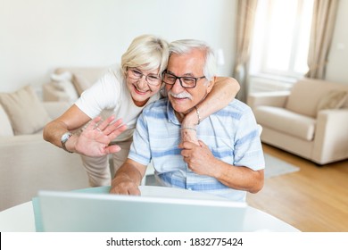 Happy old family couple talking with grandchildren using laptop , surprised excited senior woman looking at computer waving and smiling. - Powered by Shutterstock