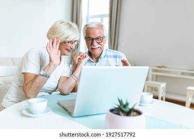 Happy Old Family Couple Talking With Friends And Family Using Laptop , Surprised Excited Senior Woman Looking At Computer Waving And Smiling.