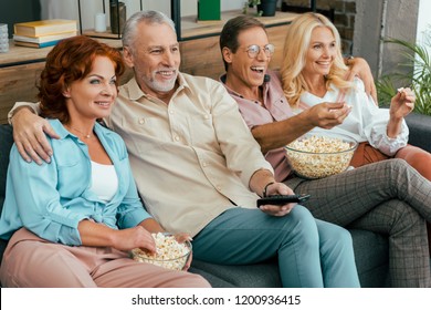 Happy Old Friends Eating Popcorn And Watching Tv Together