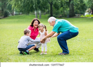 Happy Old Grandparents Having Fun With Grandchildren  In Park - Powered by Shutterstock