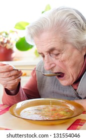 Happy Old Gray-haired Woman Eating Soup